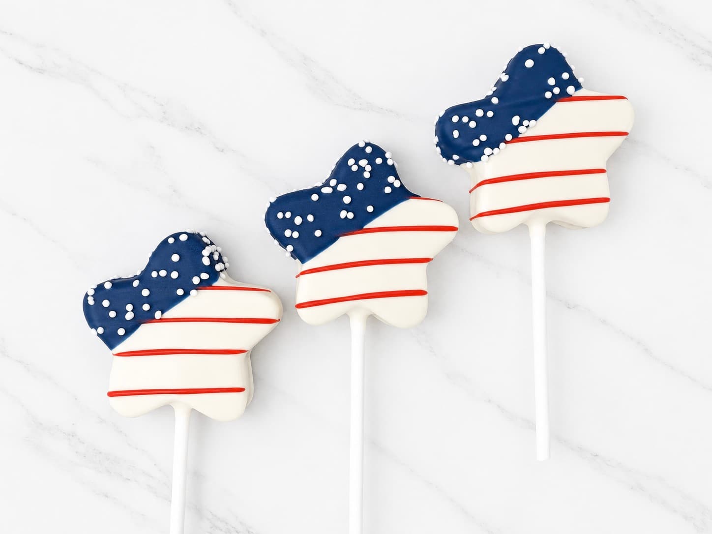 Star-shaped cake pops with red, white, and blue plaid and striped chocolate designs