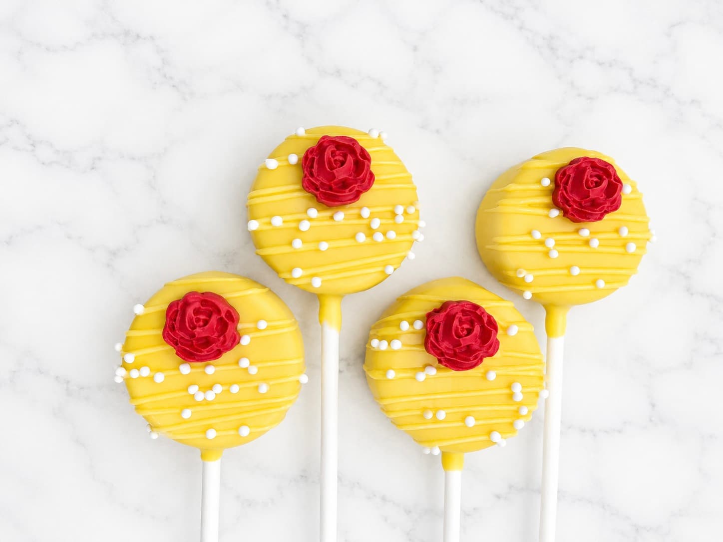 Yellow cake pops decorated with a red chocolate rose
