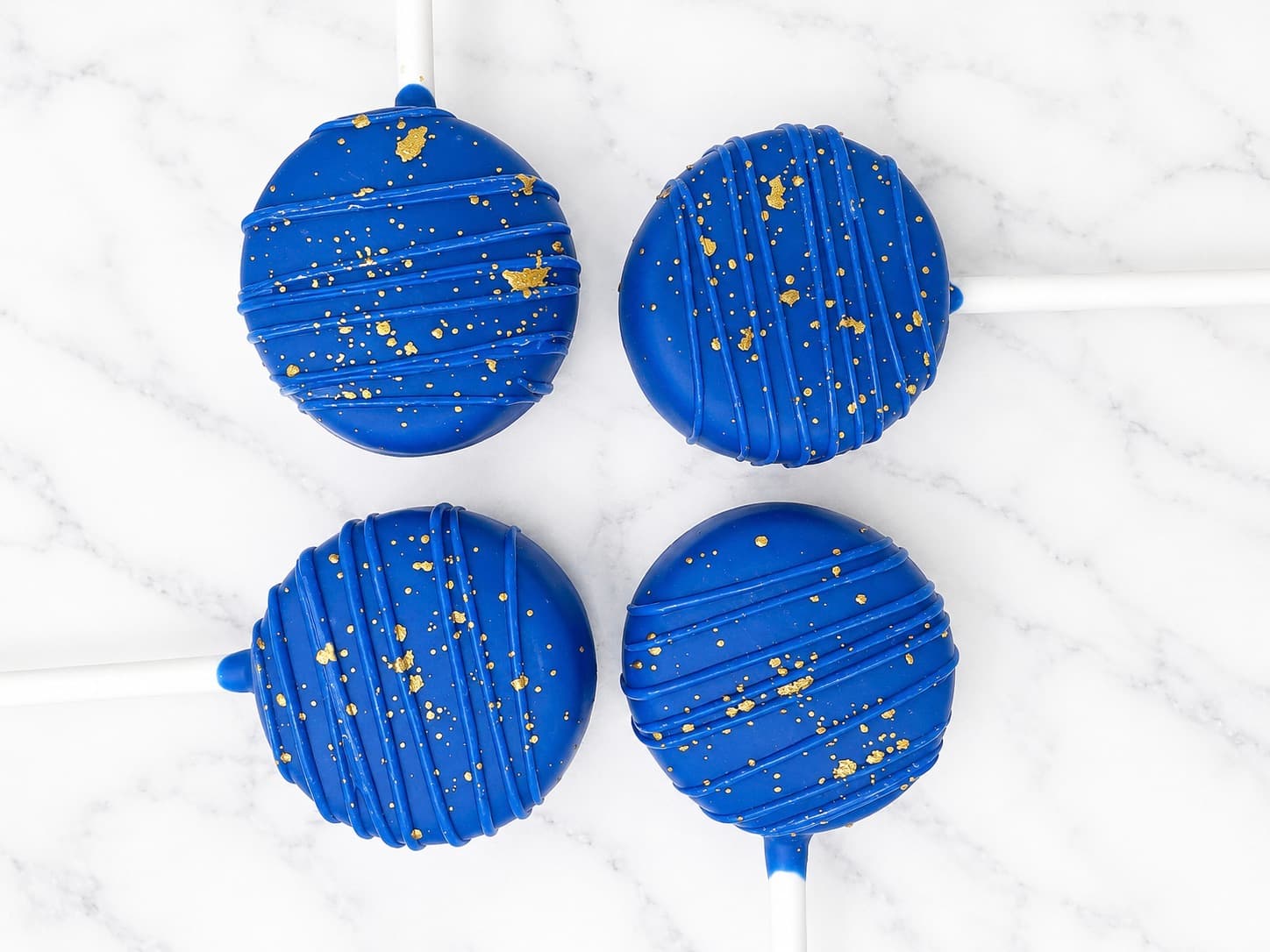 Royal blue cake pops decorated with gold leaf flecks