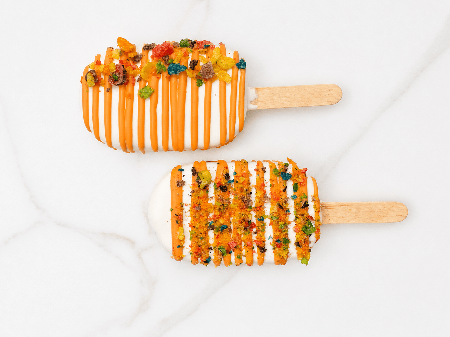 Cakesicles coated in white chocolate with orange drizzle and fruity cereal topping