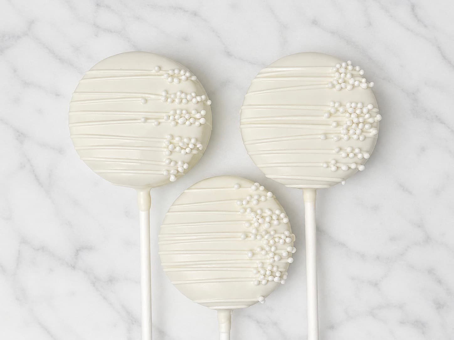 White chocolate cake pops decorated with white pearl sprinkles