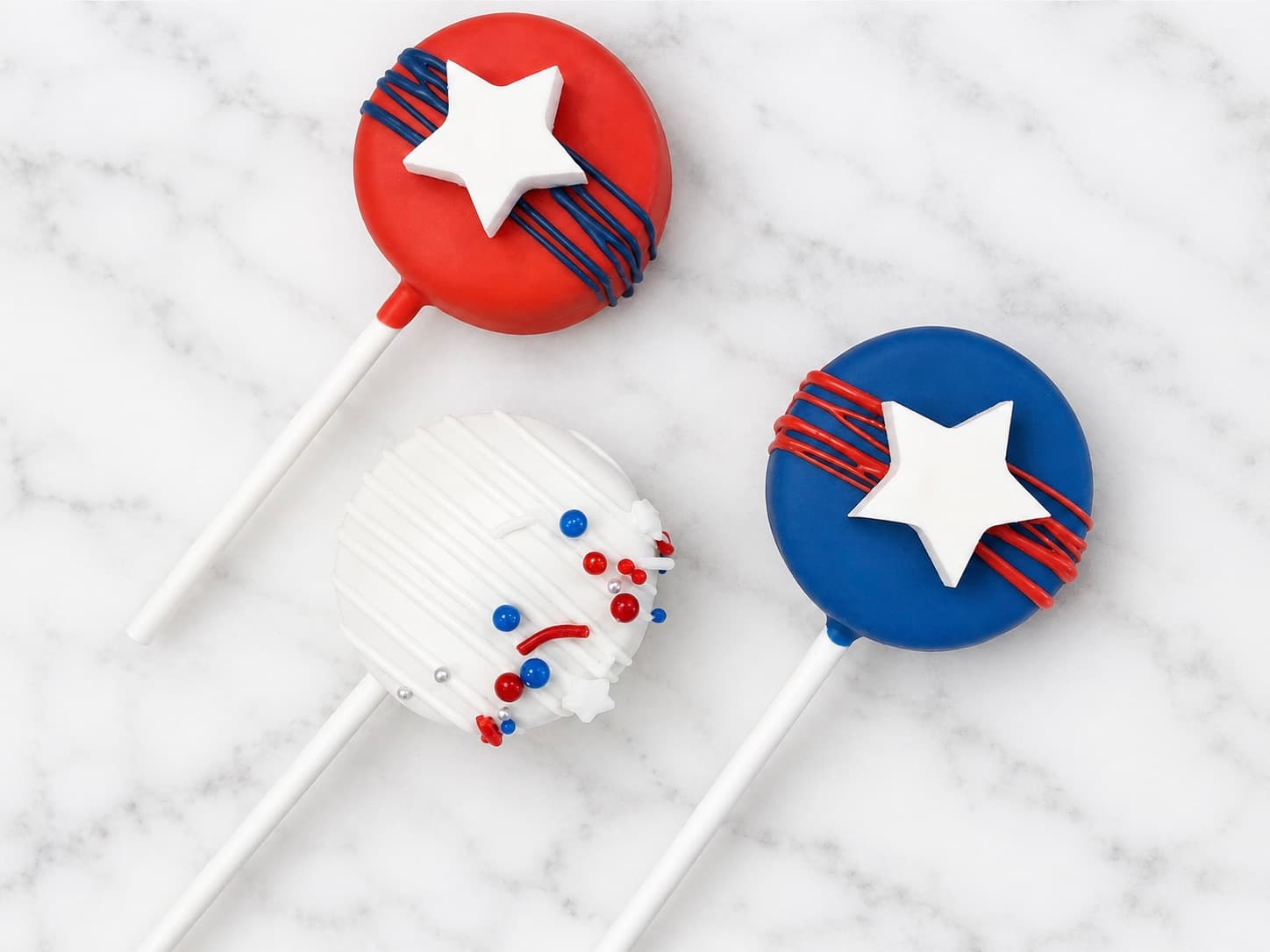 Red, white, and blue star-shaped and round cake pops with star accents and sprinkles